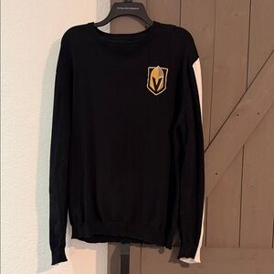Black Sweater with Golden Knight Emblem and White Sleeve Detail